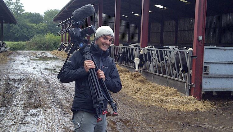 Filming on a farm. Cameraman holding camera on shoot location