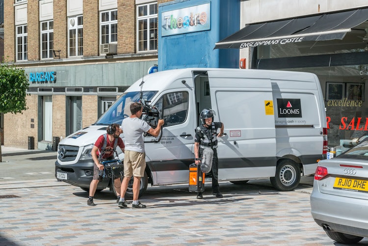 loomis driver coming out of parked van being filmed