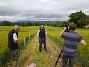 Filming the 360 video - man being filmed in crop land